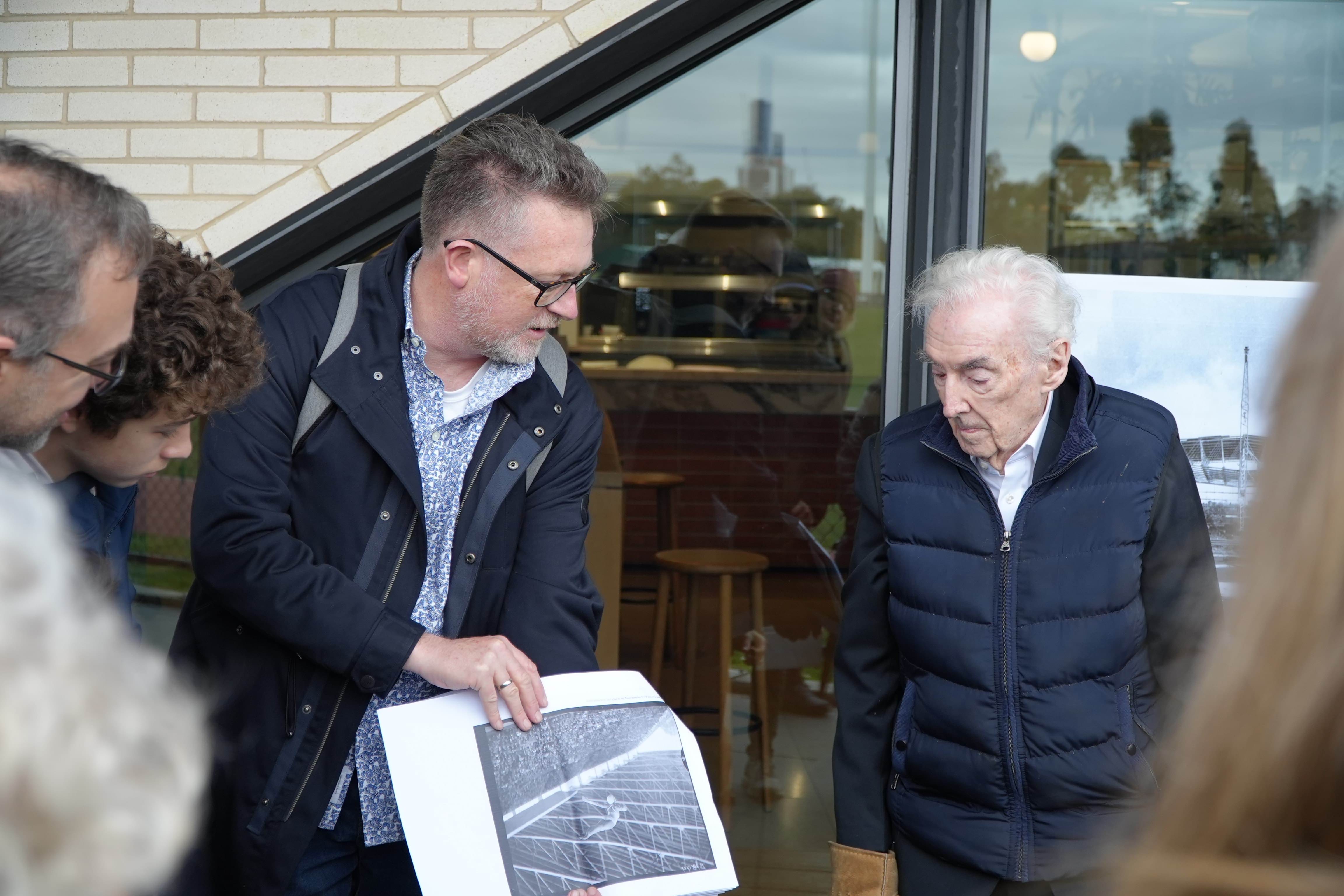 Jim Gard'ner and Peter McIntyre showing walk participants images of the 1956 olympics